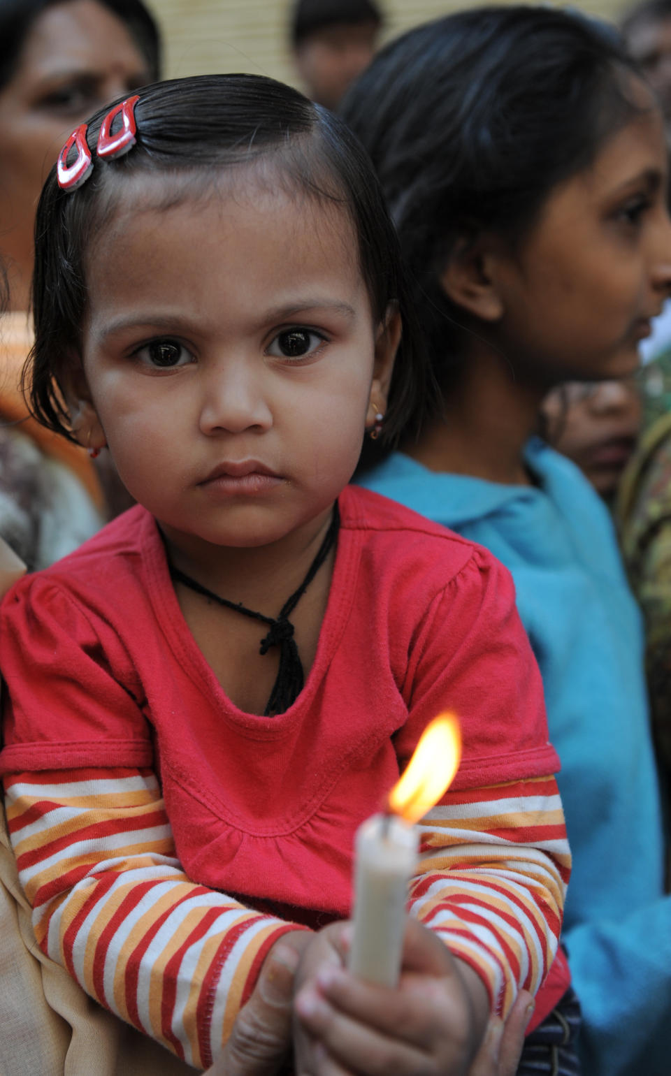  A young Indian child holds a lighted candle as she joins others during a protest rally in Ahmedabad on December 30, 2012, following the cremation of a gangrape victim in the Indian capital. (SAM PANTHAKY/AFP/Getty Images)