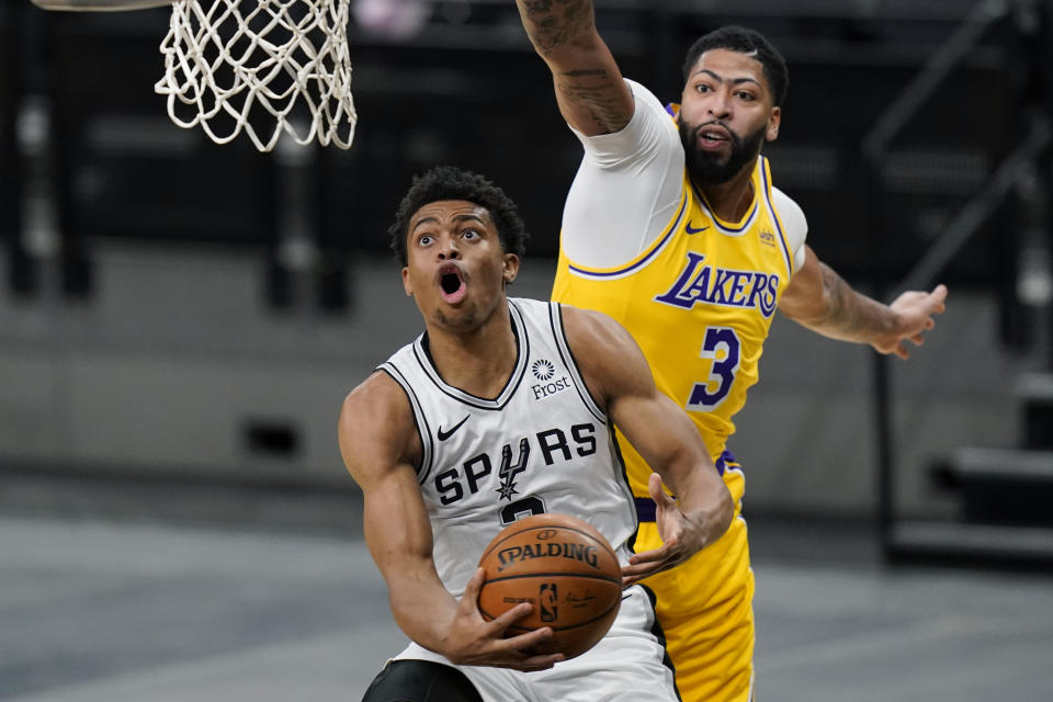San Antonio Spurs guard Keldon Johnson drives to the basket past Los Angeles Lakers forward Anthony Davis during the first half of an NBA basketball game in San Antonio, Wednesday, Dec. 30, 2020. (AP Photo/Eric Gay)