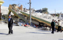 People walk past a damaged building following an earthquake in the town of Darbandikhan, near the city of Sulaimaniyah, in the semi-autonomous Kurdistan region, Iraq November 13, 2017. REUTERS/Ako Rasheed