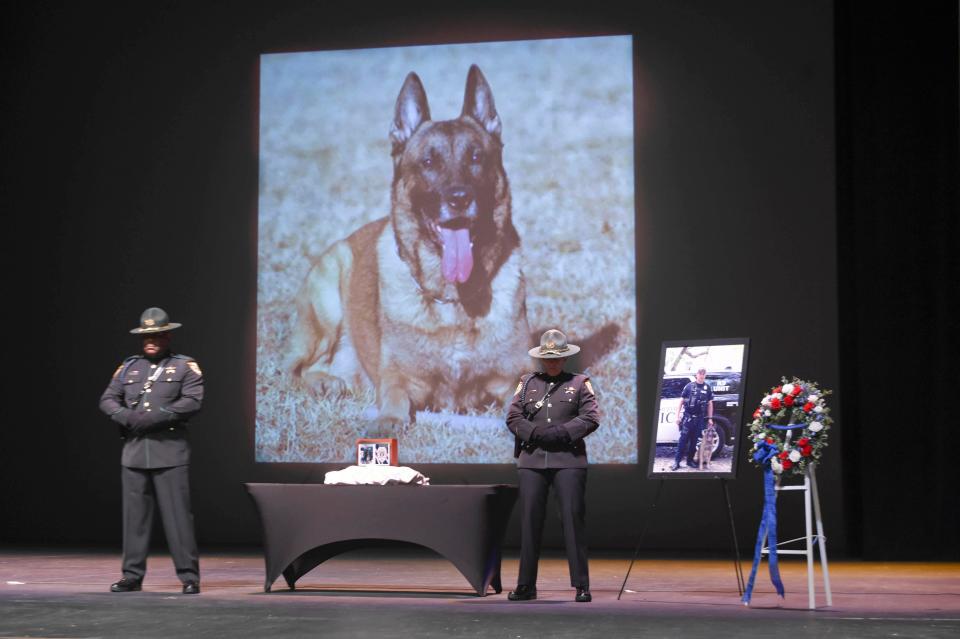 An honor guard detail stands over a memorial to Niceville K-9 Officer Blue, who died Aug. 7 in a traffic accident. On Friday, Niceville Police officers were joined by community members and officers from other law enforcement agencies to mourn and celebrate the life of Blue.