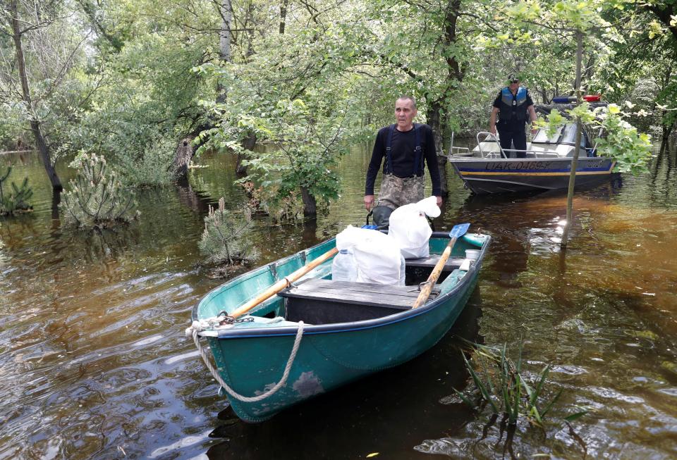 Ihor Medunov walks next to a police boat on a flooded island which locals and officials say is caused by Russia’s chaotic control of the Kakhovka dam downstream, amid Russia’s attack on Ukraine, near Zaporizhzhia (REUTERS)