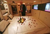 A journalist inspects a double bed first class suite during a media tour of the Airbus A380 superjumbo after it landed at Singapore's Changi Airport in this October 17, 2007 file photo. With limousine pick-ups and on-board chefs, Asia's premium airlines are investing hundreds of millions of dollars on luxury services in a bet on a rebound in business from the wealthy, even as low-cost carriers fly high with the booming middle class. To match story ASIA-AIRLINES/LUXURY REUTERS/Vivek Prakash/Files (SINGAPORE - Tags: TRANSPORT BUSINESS SOCIETY)