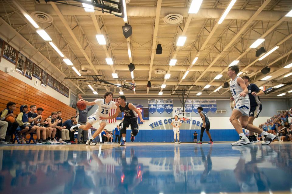 Barron Collier's Anthony Cancelleri (23) drives against Southwest Florida Christian Academy's Yadniel Sanabria (12) during the varsity boys basketball game between SFCA and Barron Collier, Tuesday, Nov. 30, 2021, at Barron Collier High School in Naples, Fla.Barron Collier defeated SFCA 82-77 in overtime.