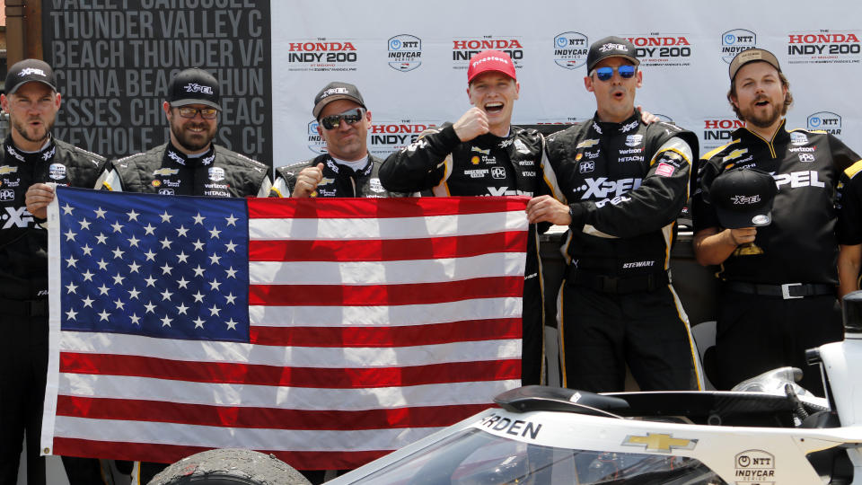 Josef Newgarden celebrates with his team in victory lane after winning an IndyCar race at Mid-Ohio Sports Car Course in Lexington, Ohio, Sunday, July 4, 2021. (AP Photo/Tom E. Puskar)