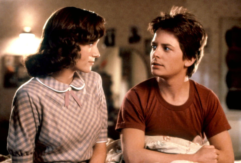 Marty McFly and Lorraine Baines in a scene from Back to the Future, sitting close with anxious expressions