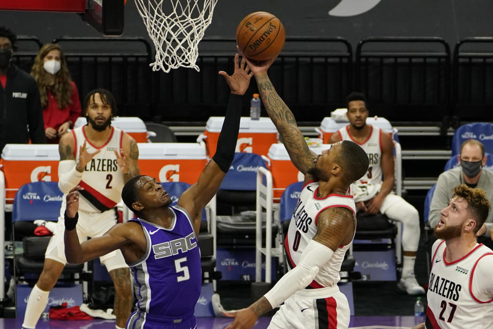 Portland Trail Blazers guard Damian Lillard, right, goes to the basket against Sacramento Kings guard De'Aaron Fox, left, during the first quarter of an NBA basketball game in Sacramento, Calif., Wednesday, Jan. 13, 2021. (AP Photo/Rich Pedroncelli)