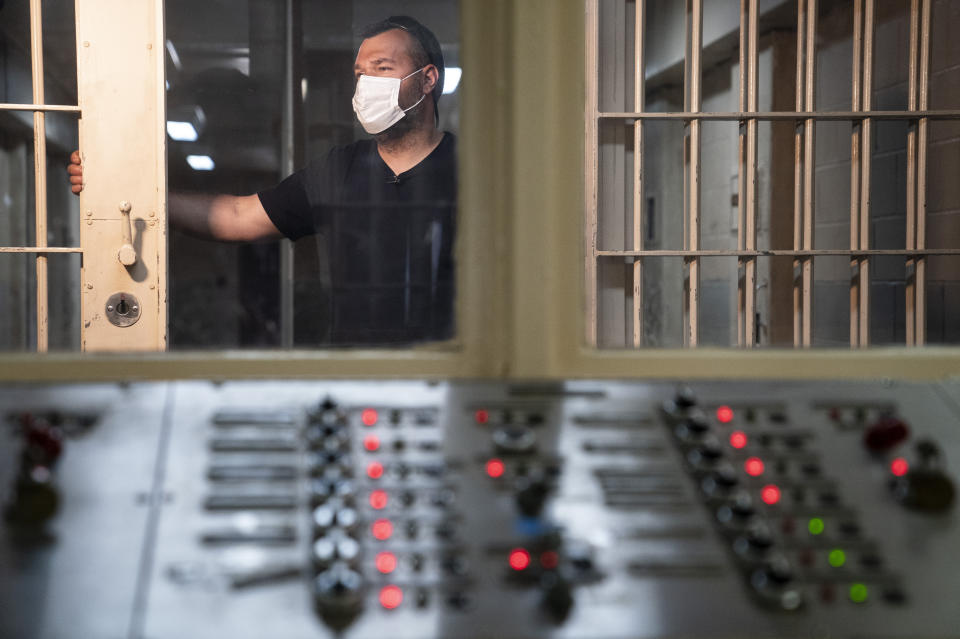 Jimmy Pilinci, studio and grounds manager, walks through the repurposed Special Housing Unit wing for prisoner solitary confinement where a working door control panel remains activated at the former Arthur Kill Correctional Facility, Tuesday, May 11, 2021, in the Staten Island borough of New York. The facility was purchased by Broadway Stages in 2017 and has been transformed into a film and television studio. Much of the prison was preserved as a set, lending authenticity to scenes in productions. Five other sound stages are being built on the 69-acre site, giving production companies the ability to shoot entire projects. (AP Photo/John Minchillo)