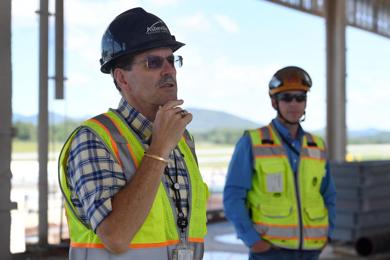 Lew Bleiweis, Asheville Regional Airport’s president and CEO, talks with the media while standing in the new north concourse, currently under construction, June 7, 2024. Also pictured is John Baumeister, AVL Forward's project manager.