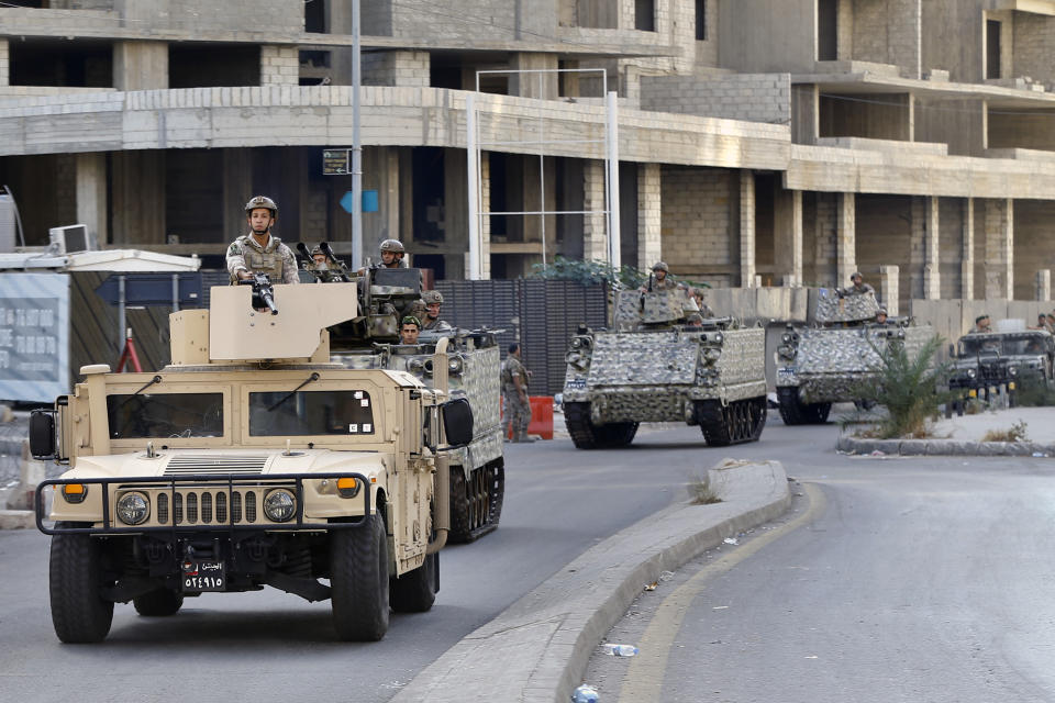 Lebanese army soldiers on armed vehicles patrol at the site where deadly clashes that erupted Thursday along a former 1975-90 civil war front-line between Muslim Shiite and Christian areas, in Ain el-Remaneh neighborhood, Beirut, Lebanon, Friday, Oct. 15, 2021. Schools, banks and government offices across Lebanon shut down Friday after hours of gun battles between heavily armed militias killed six people and terrorized the residents of Beirut. (AP Photo/Bilal Hussein)