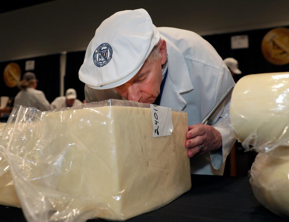 U.S. Championship Cheese Contest judge Larry Bell smells a block of swiss before tasting it during the event on Feb. 21, 2023, in Ashwaubenon, Wis.
