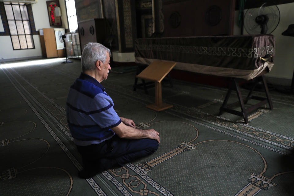 The father of Ibrahim Harb, 35, a Lebanese man who was critically injured in the massive explosion at Beirut's port last year and who died on Monday nearly 14 months after the blast, prays at a mosque next of his son's coffin in Beirut, Lebanon, Tuesday, Sept. 28, 2021. On August 4, 2020, hundreds of tons of ammonium nitrate, a highly explosive material used in fertilizers, ignited after a massive fire at the port. The death brings to at least 215 the number of people who have been killed by the blast, according to official records. (AP Photo/Hussein Malla)