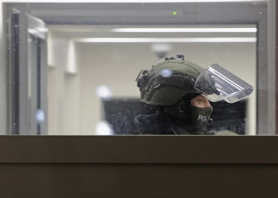 A police officer stands in an apartment building during raids against an Islamist network at the Maerkische Viertel neighborhood in Berlin, Thursday, Feb. 25, 2021. Police searched the apartments of several alleged supporters of a banned Islamic extremist organization in the German capital. (Paul Zinken/dpa via AP)