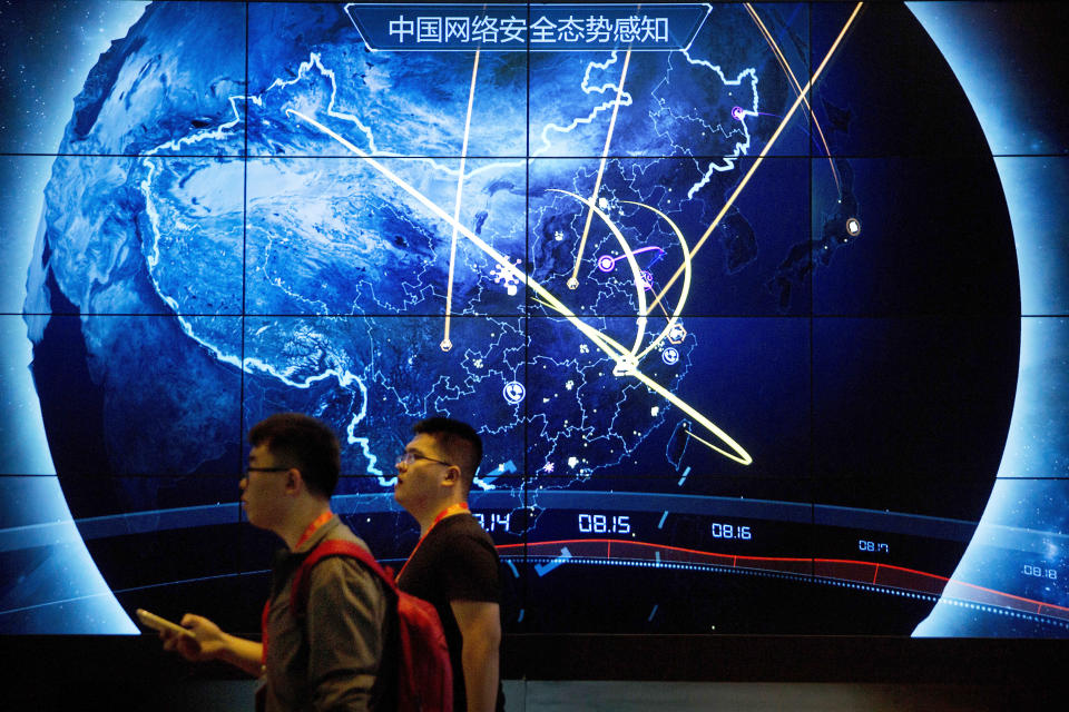 FILE - Attendees walk past an electronic display showing recent cyberattacks in China at the China Internet Security Conference in Beijing, on Sept. 12, 2017. Hackers linked to China were likely behind the exploitation of a software security hole in cybersecurity firm Barracuda Networks’ email security feature that affected public and private organizations globally, according to an investigation by security firm Mandiant. (AP Photo/Mark Schiefelbein, File)