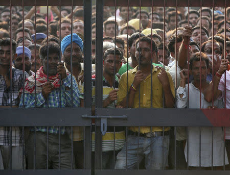 Onlookers stand at the gate of a police station where a gunfight took place inDinanagar town in Gurdaspur district of Punjab, July 27, 2015. REUTERS/Mukesh Gupta