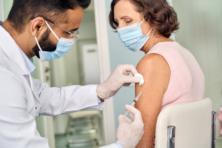 A woman receives a vaccination.