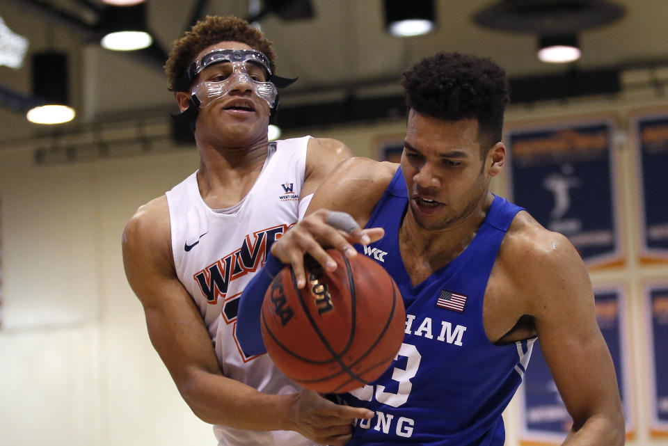 BYU forward Yoeli Childs, right, and Pepperdine forward Kameron Edwards (20) struggle for the ball during the second half of an NCAA college basketball game Saturday, Feb. 29, 2020, in Malibu, Calif. (AP Photo/Ringo H.W. Chiu)
