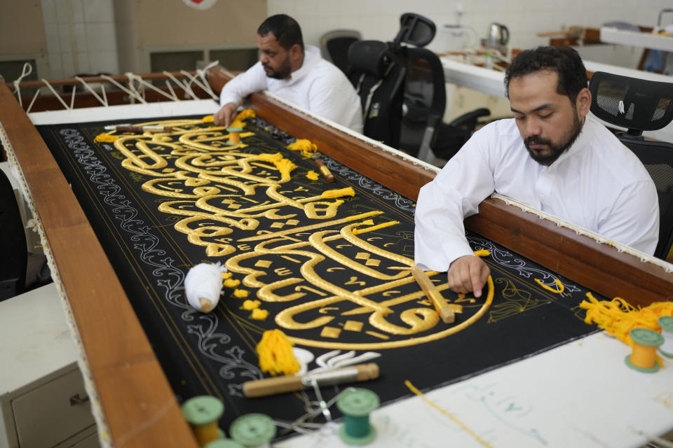 Saudi men embroiders Islamic calligraphy, using either pure silver threads or silver threads plated with gold, during the final stages in the preparation of a drape, or Kiswa, that covers the Kaaba, a cube-shaped structure at the heart the Grand Mosque, at the Kiswa factory in Mecca, Saudi Arabia, Thursday, June 13, 2024. (AP Photo/Rafiq Maqbool)
