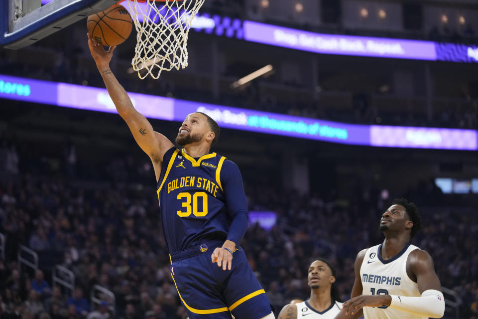 Golden State Warriors guard Stephen Curry, left, shoots against the Memphis Grizzlies during the first half of an NBA basketball game in San Francisco, Wednesday, Jan. 25, 2023. (AP Photo/Godofredo A. Vásquez)