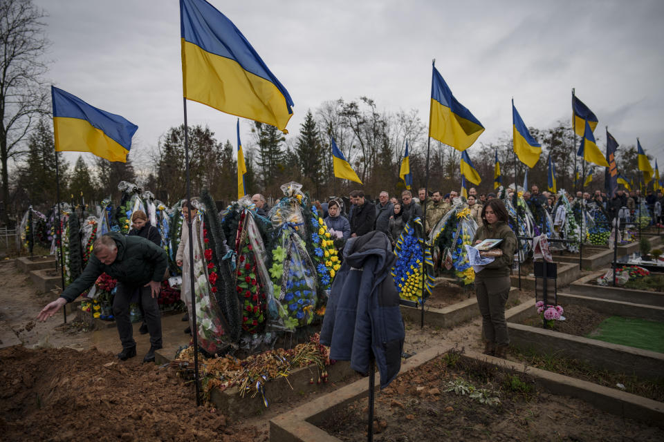 People line up to throw dirt in the grave during the farewell for Ukrainian Cpt. Serhii Vatsko in Boiarka, Ukraine, Friday, March 29, 2024. Vatsko, who was killed on the frontline of eastern Ukraine on March 24 joined the country's military in 2014. (AP Photo/Vadim Ghirda)