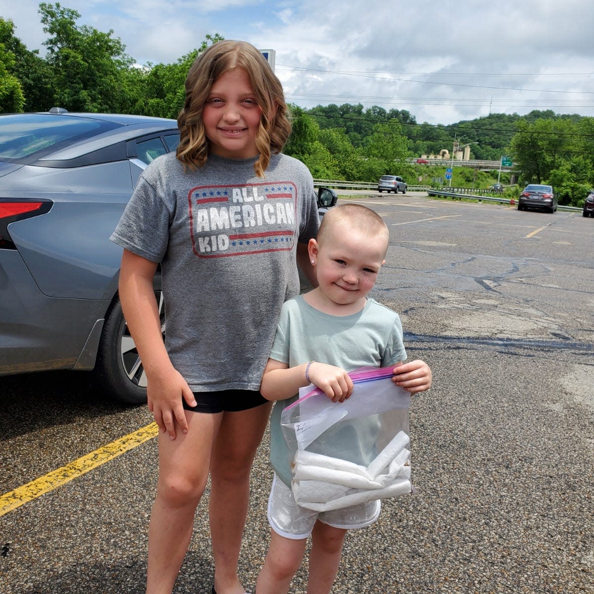 After cutting 11 inches from her hair, Hailey Workman,12, of Winterset, gives the hair to her cousin Addie Reed, 7, Senecaville who is suffering from hair loss due to chemotherapy to treat her AML leukemia. Addie's mother, Pam, also cut her hair so the 6-year-old will soon have two wigs.