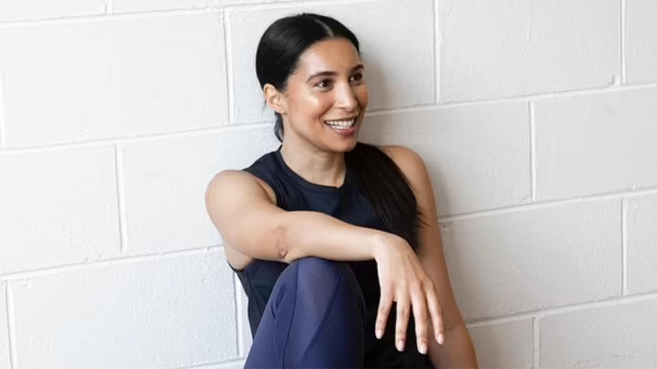 This photo shows former Matildas defender Elissia Carnavas sitting against a wall.