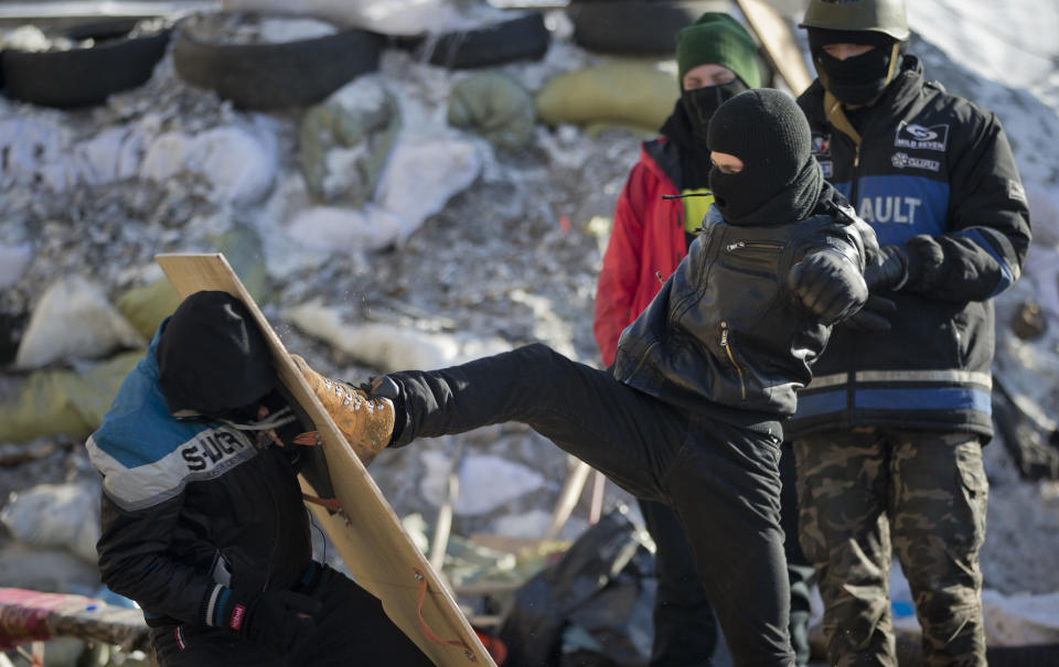 Members of the radical group Pravy Sektor (Right Sector) practice street fighting in central Kiev, Ukraine, Monday, Feb. 3, 2014. Ukraine's president will return Monday from a short sick leave that had sparked a guessing game he was taking himself out of action in preparation to step down or for a crackdown on widespread anti-government protests. (AP Photo/Darko Bandic)