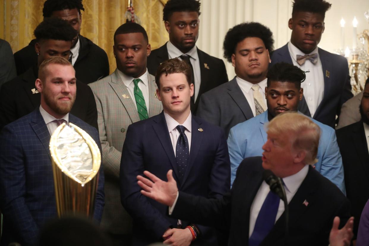 Members of the LSU Tigers look on as Donald Trump makes jokes at a reception for them in the East Room of the White House to reward their victory in the college football playoff final: Getty Images