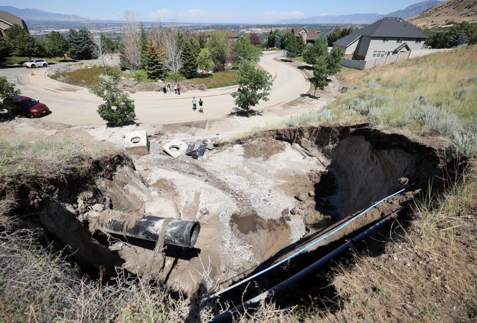 People look at the aftermath of a mudslide near Rambling Road and Sage Hollow Drive in Draper on Friday, Aug. 4, 2023. Draper Mayor Troy Walker declared a state of emergency due to flooding. | Kristin Murphy, Deseret News