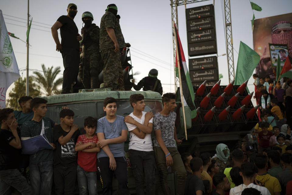 Palestinians gather as Hamas militants parade at a rally just over a week after a cease-fire was reached in an 11-day war between Hamas and Israel, Sunday, May 30, 2021, in Beit Lahia, northern Gaza Strip. (AP Photo/Felipe Dana)