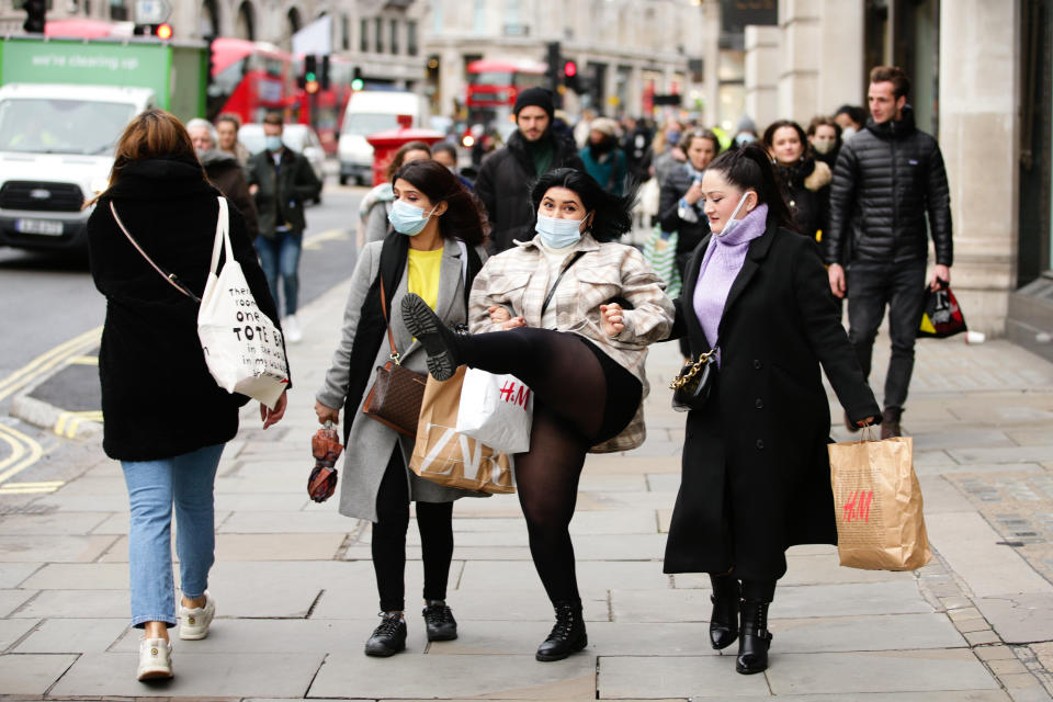 A shopper wearing a face mask strikes a pose on Regent Street in London, England, on December 4, 2020. London has returned to so-called Tier 2 or 'high alert' coronavirus restrictions since the end of the four-week, England-wide lockdown on Wednesday, meaning a reopening of non-essential shops and hospitality businesses as the festive season gets underway. Rules under all three of England's tiers have been strengthened from before the November lockdown, however, with pubs and restaurants most severely impacted. In London's West End, Oxford Street and Regent Street were both busy with Christmas shoppers this afternoon, meanwhile, with the retail sector hoping for a strong end to one of its most difficult years. (Photo by David Cliff/NurPhoto via Getty Images)