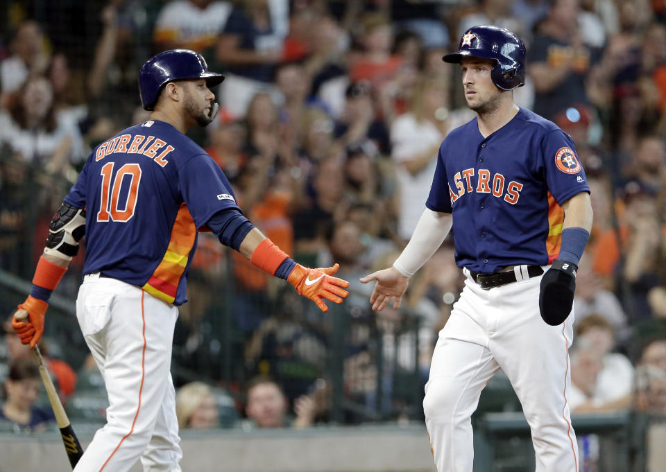 Houston Astros first baseman Yuli Gurriel (10) congratulates Alex Bregmam, right, after he scored on the hit by Carlos Correa during the fourth inning of a baseball game against the Seattle Mariners Sunday, Aug. 4, 2019, in Houston. (AP Photo/Michael Wyke)