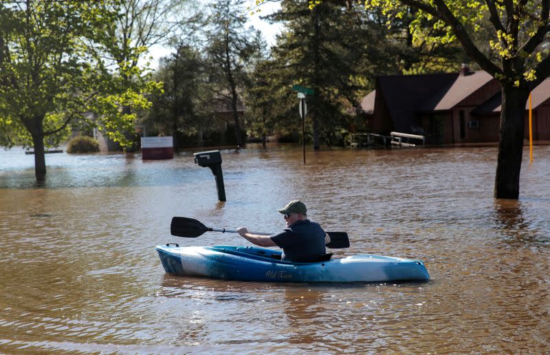 Resident Joe Ryan paddles a kayak to check on his home in a flooded neighborhood along the Tittabawassee River, after the two dam failures in Midland, Michigan