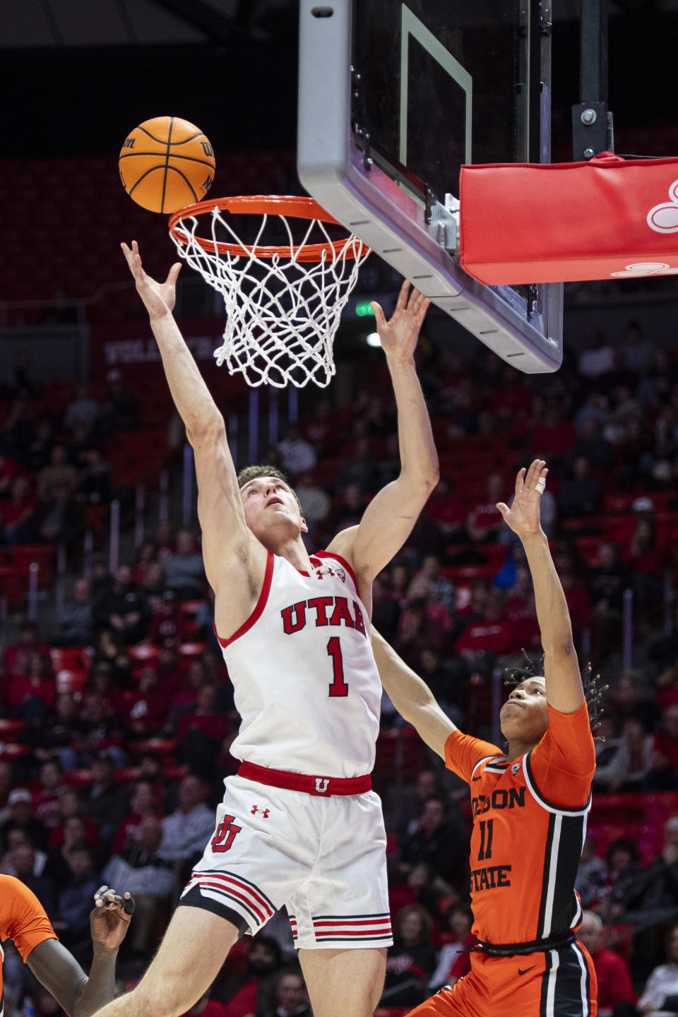 Utah forward Ben Carlson (1) lays up the ball while guarded by Oregon State guard DaJohn Craig (11) during the second half of an NCAA college basketball game Thursday, Jan. 18, 2024, in Salt Lake City. (AP Photo/Isaac Hale)