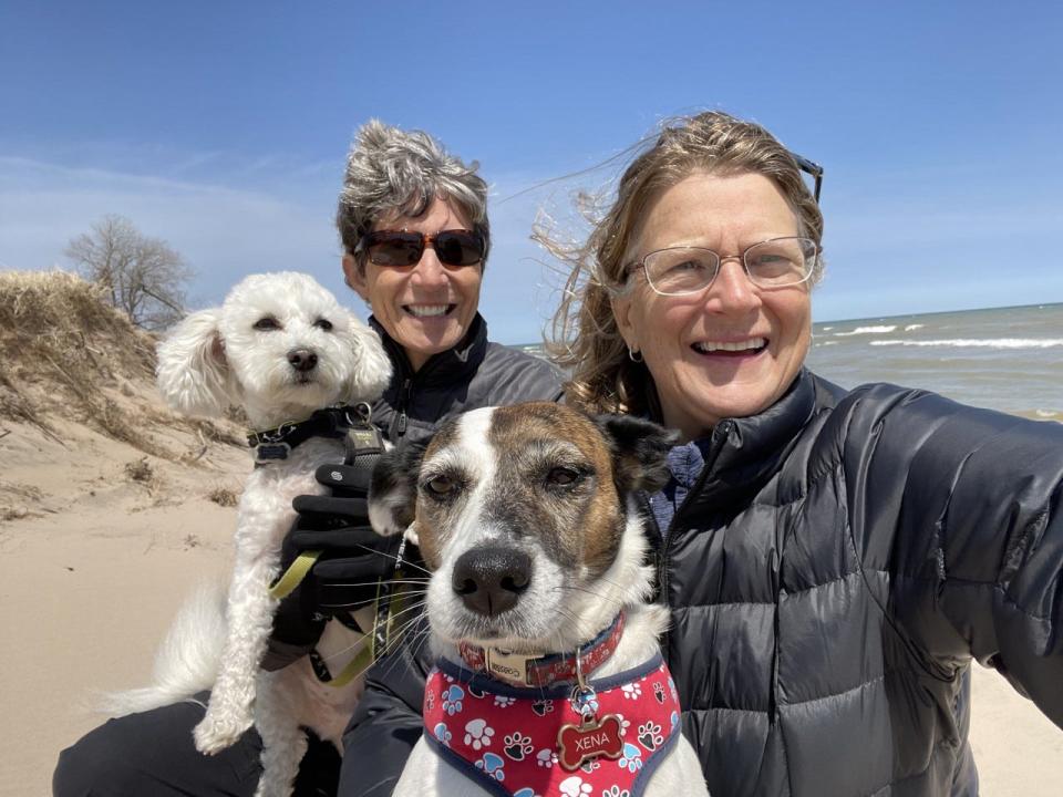 Heidi Wasson, left, and Nancy Gilliom pose for a photo with their dogs on the beach at Kohler Andrae State Park where they were volunteering in the nature center in May 2022.