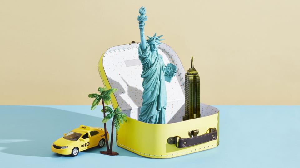 Statue of Liberty figurine in yellow lunch box with New York City memorabilia.