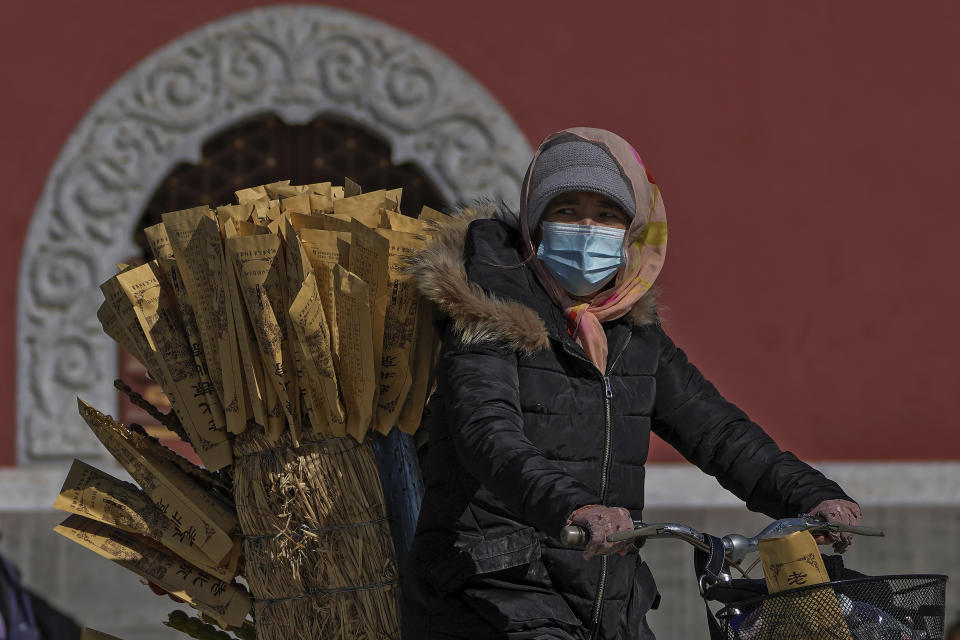 A vendor rides on a bicycle selling sugar-coated Chinese haw at a public park in Beijing, Monday, Oct. 10, 2022. (AP Photo/Andy Wong)