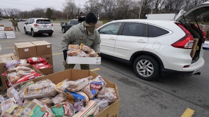 Corpl. James Bates carries a box of groceries to a car at a food bank distribution by the Greater Cleveland Food Bank in Cleveland. Food banks across America say these economic conditions are pushing demand for their support higher, at a time when their labor and delivery costs are climbing and donations are decreasing. (Photo: Tony Dejak/AP, File)