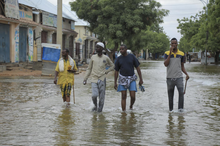 Men walk through floodwaters on a street in the town of Beledweyne, in Somalia, Monday, May 15, 2023. Estimates from the UN Office for the Coordination of Humanitarian Affairs are that 460,000 people have been affected by flooding caused by heavy rains since mid-March. (AP Photo)
