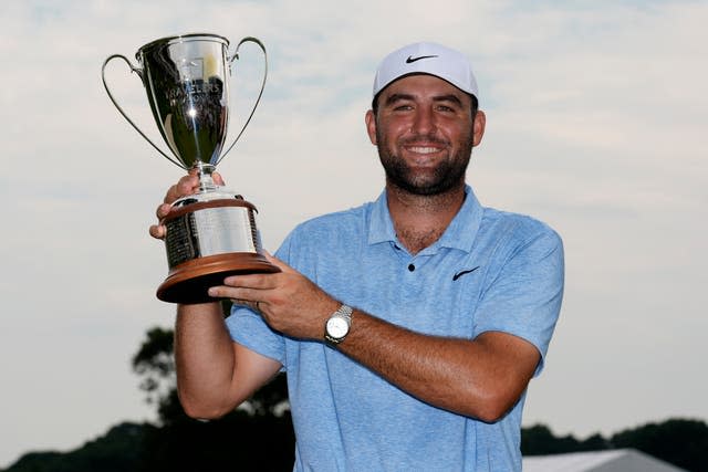 Scottie Scheffler holds a trophy after winning the Travelers Championship