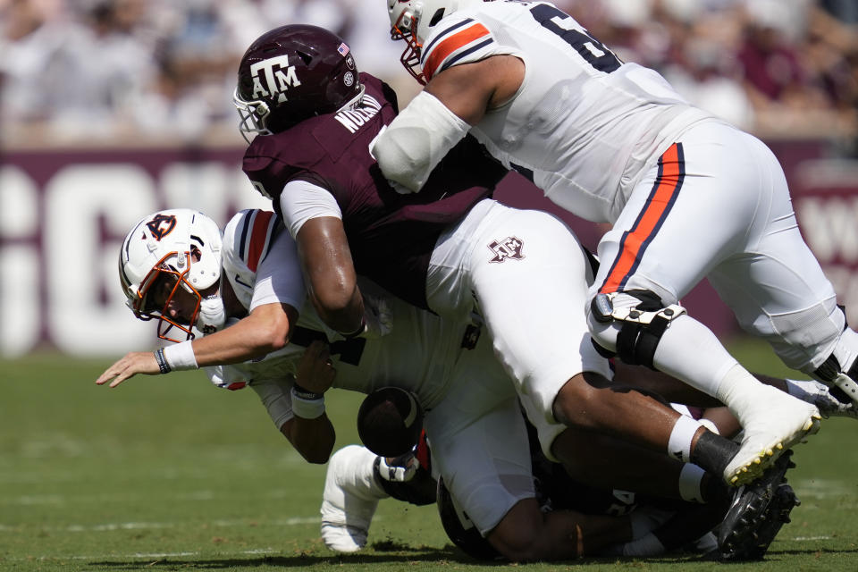 Auburn quarterback Payton Thorne, left, is sacked by Texas A&M defensive lineman Walter Nolen, right, and linebacker Chris Russell Jr., bottom, during the first half of an NCAA college football game Saturday, Sept. 23, 2023, in College Station, Texas. (AP Photo/Sam Craft)