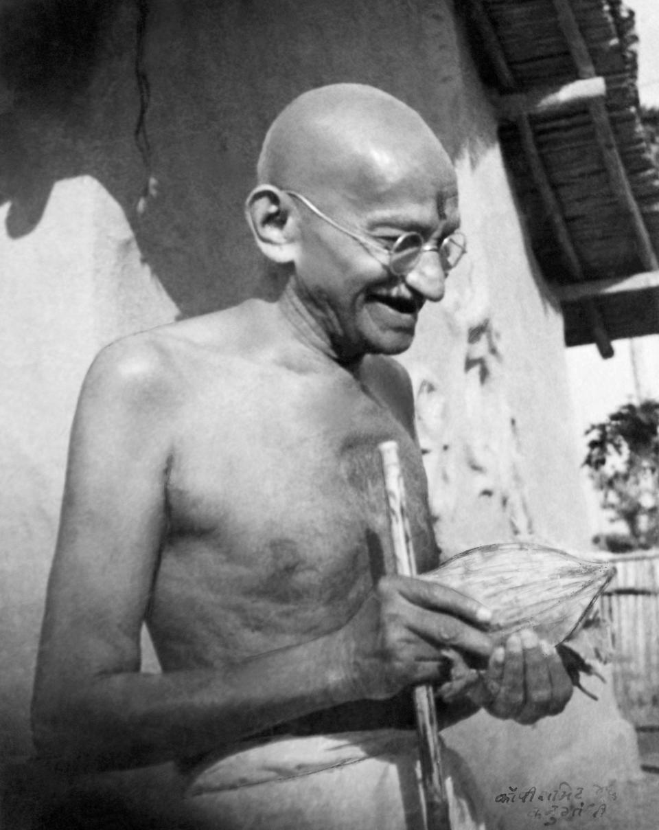 Gandhi, who was known to love fruit, receives a coconut in front of his hut at Sevagram Ashram in January 1942. (Photo: Dinodia Photos via Getty Images)