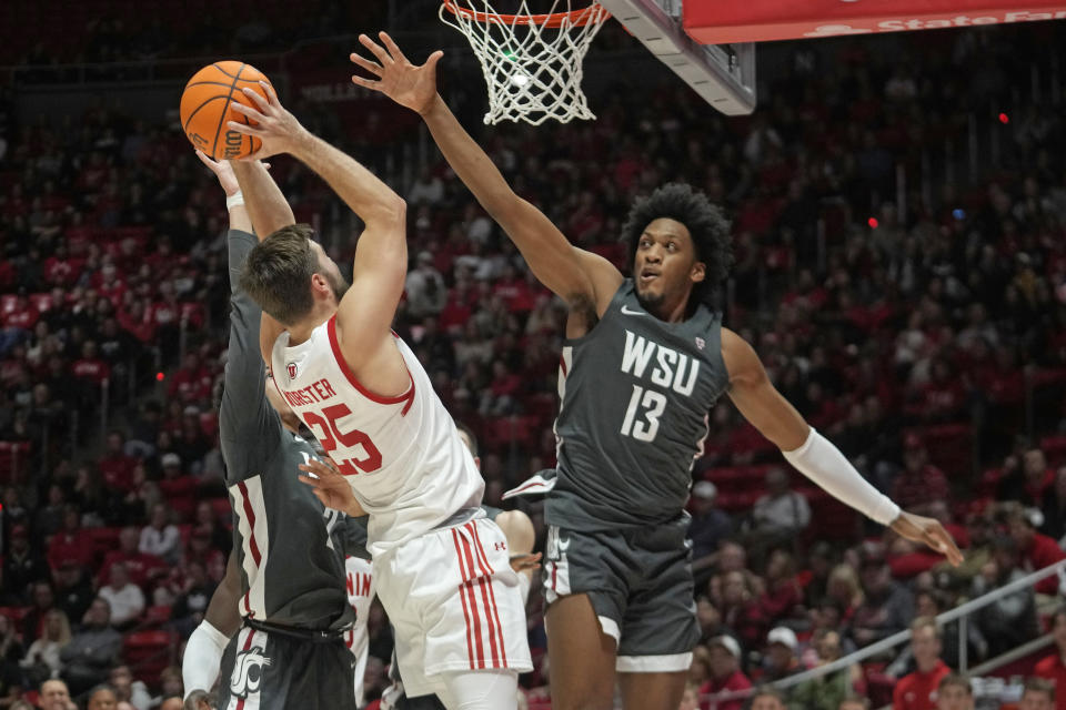 Washington State forward Isaac Jones (13) defends against Utah guard Rollie Worster (25) during the second half of an NCAA college basketball game Friday, Dec. 29, 2023, in Salt Lake City. (AP Photo/Rick Bowmer)