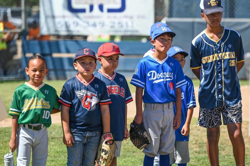 Sunnyside Little Leaguers watch the activities as a rendering for a new snack bar, press box and restroom facility is unveiled at Bakman Field in Fresno’s Sunnyside area on Tuesday, July 11, 2023.