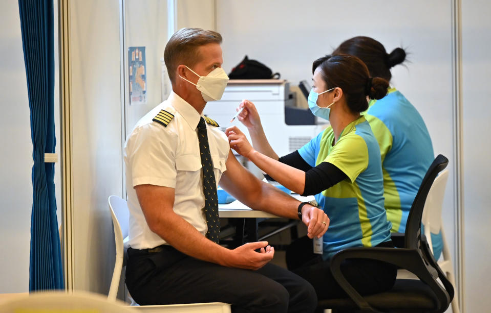A Cathay Pacific pilot receives China's Sinovac COVID-19 coronavirus vaccine at a community vaccination centre in Hong Kong Tuesday, Feb. 23, 2021. Frontline workers and high risk people are the first in line to be vaccinated in the territory.(Peter Parks/Pool Photo via AP)