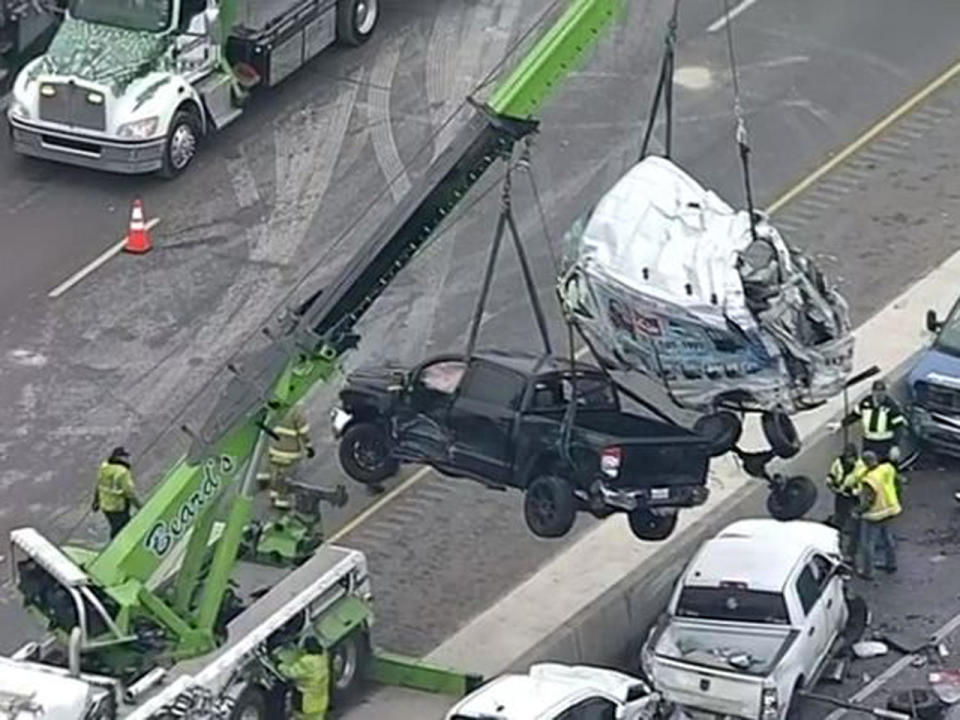 An image capture of aerial footage shows a crane lifting two vehicles from a massive pileup on Interstate 35 in Fort Worth, Texas, February 11, 2021. / Credit: KTVT