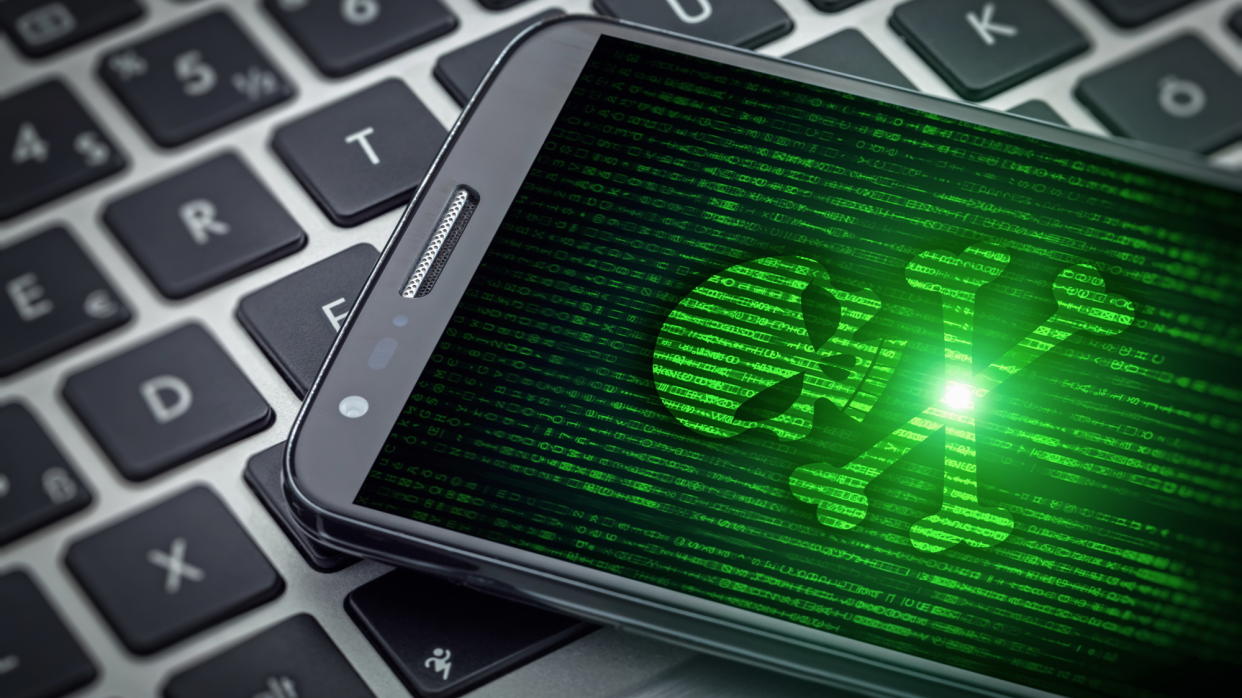  Green skull on smartphone screen. 