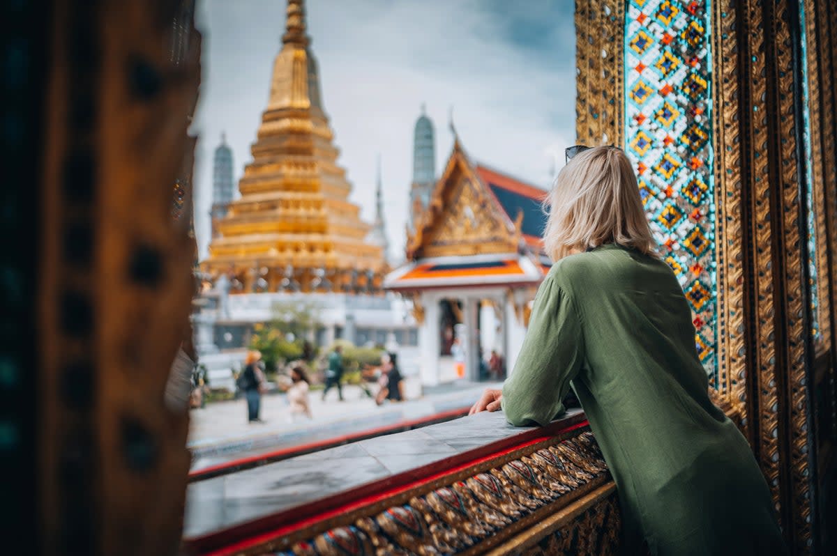 Shelter from the rain of the wet season in the Grand Palace, Bangkok (Getty Images)