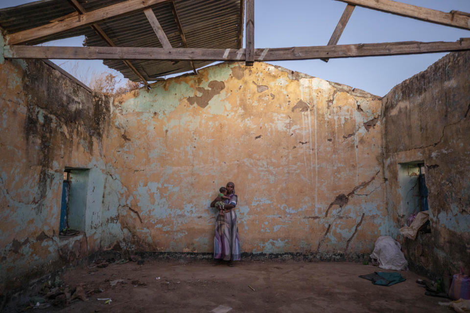 A Tigray woman who fled the conflict in Ethiopia's Tigray region holds her child inside of her temporary shelter at Umm Rakouba refugee camp in Qadarif, eastern Sudan, Monday, Dec. 7, 2020. (AP Photo/Nariman El-Mofty)