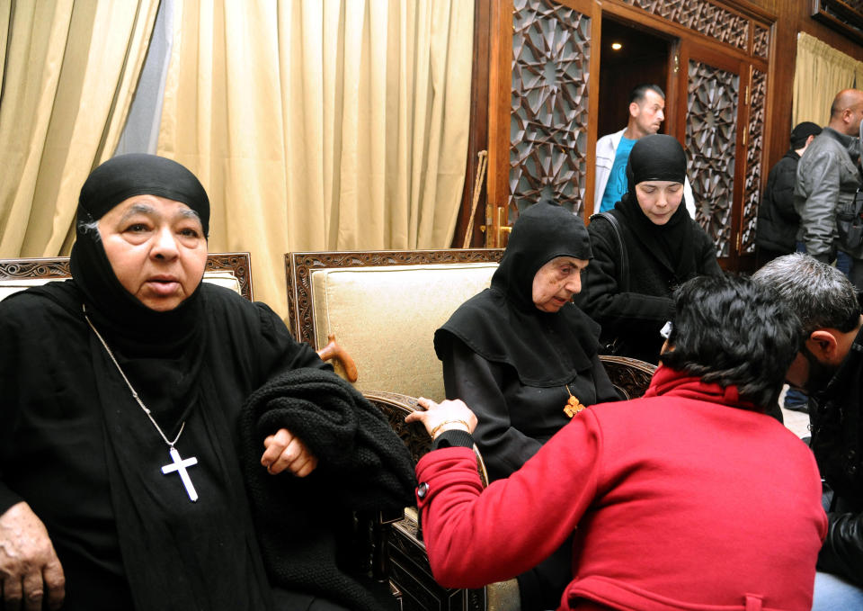 In this photo released by the Syrian official news agency SANA, a group of nuns, who were freed after being held by Syrian rebels, greet church officials at the Syrian border town of Jdeidat Yabous, early Monday, March. 10, 2014. Rebels in Syria freed more than a dozen Greek Orthodox nuns on Monday, ending their three-month captivity in exchange for Syrian authorities releasing dozens of female prisoners. The release of the nuns and their helpers, 16 women in all, is a rare successful prisoner-exchange deal between Syrian government authorities and the rebels seeking to overthrow the rule of President Bashar Assad. (AP Photo/SANA)