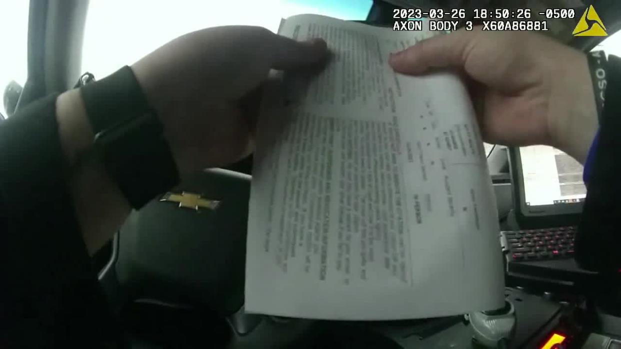 <div>Police officers folds a ticket during a traffic stop</div>